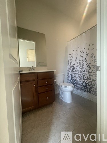 A bathroom with a toilet, sink, and shower.