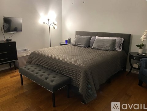 A bedroom with a large bed and a bench in front of it.