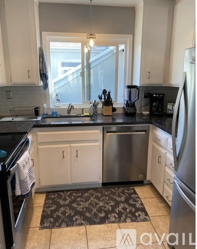 A kitchen with a sink, dishwasher, and refrigerator.