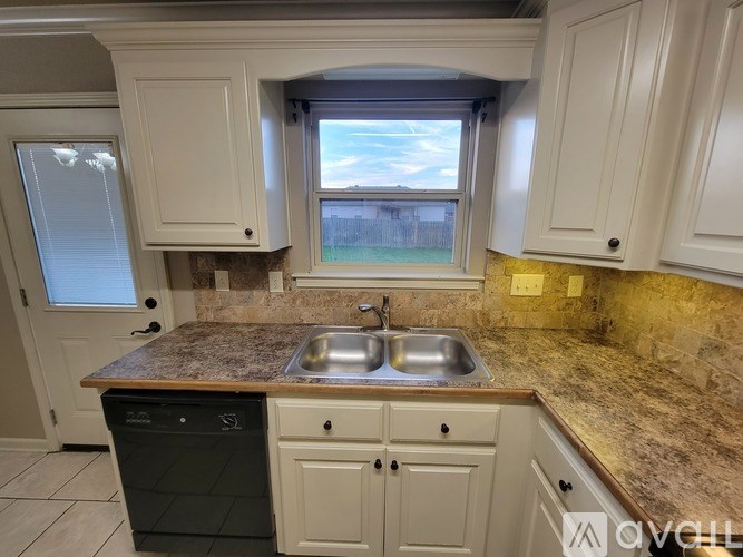 A kitchen with a granite countertop and a window.