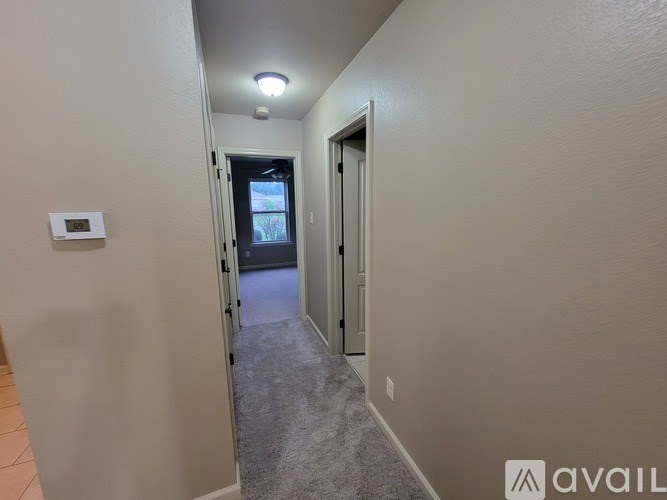 A hallway with a door on the right and a window on the left.