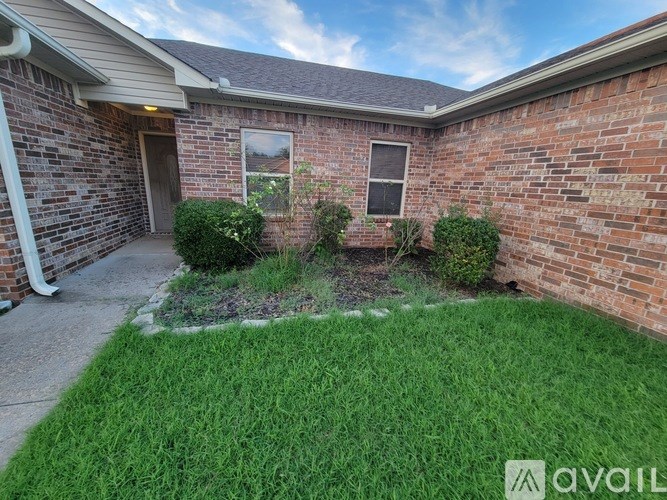 A brick house with a small garden in front.