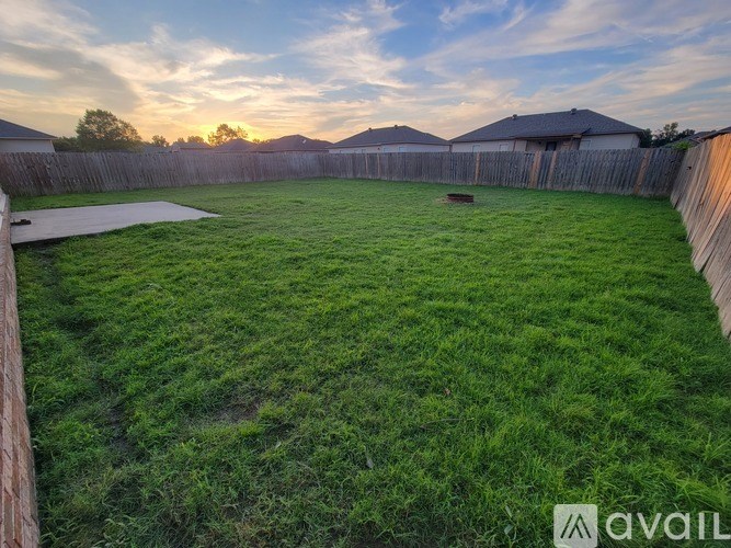 A backyard with a wooden fence and a shed.