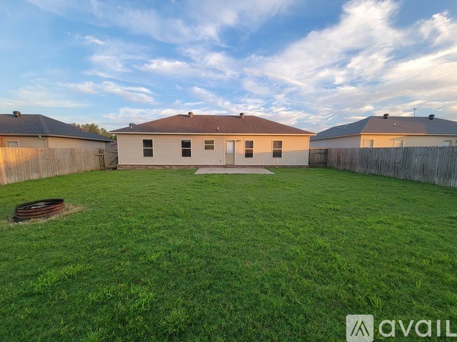 A backyard with a fence and a house.