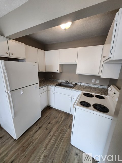 A kitchen with white appliances and cabinets.