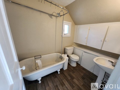 A bathroom with a white tub, toilet, and sink.