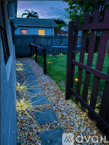 A wooden fence with a gate stands in front of a house.