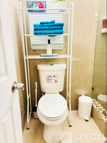 A white toilet with a white tank and a white toilet paper holder.