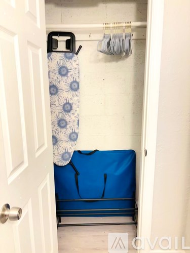 A blue and white patterned object is on the floor next to a white door.