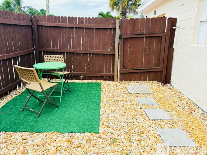 A patio with a green table and chairs.