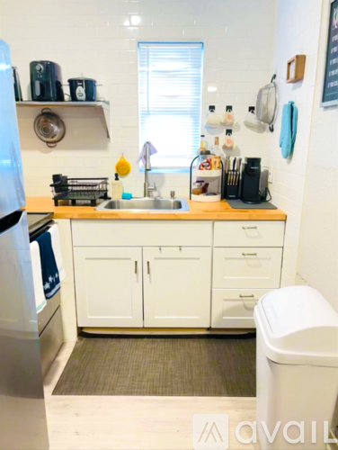 A kitchen with white cabinets and a wooden countertop.