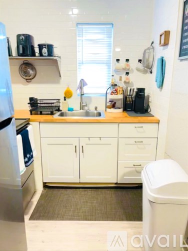 A kitchen with white cabinets and a wooden countertop.