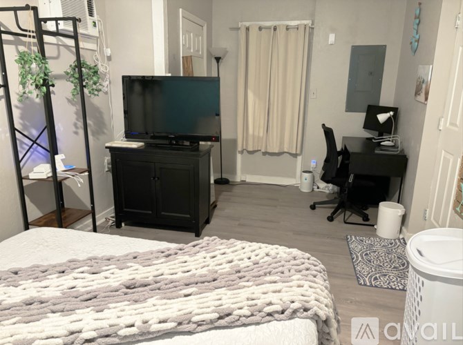 A bedroom with a bed, desk, and chair.