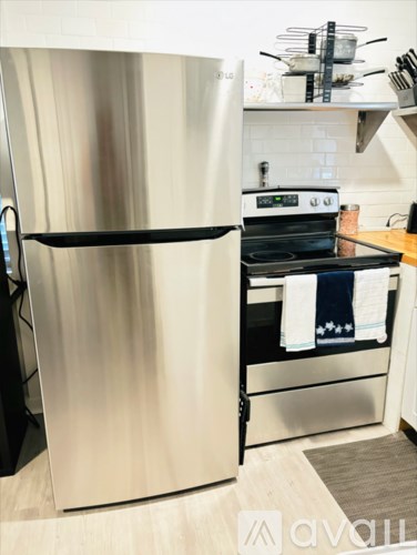 A stainless steel refrigerator with a black handle is in a kitchen.
