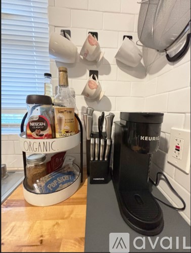 A kitchen counter with a jar of Nescafe organic coffee and a Keurig coffee maker.