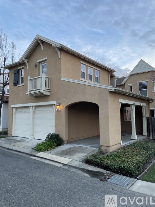 A two-story house with a beige exterior and a white garage door.