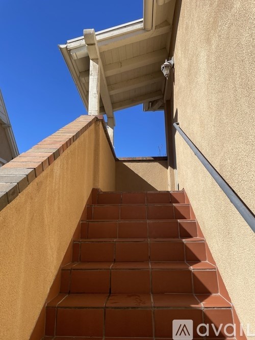 A staircase with a beige wall and a white roof.