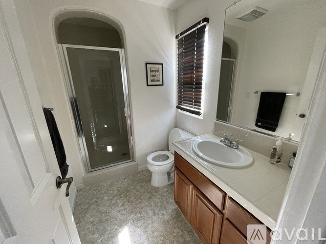 A bathroom with a toilet, sink, and mirror.