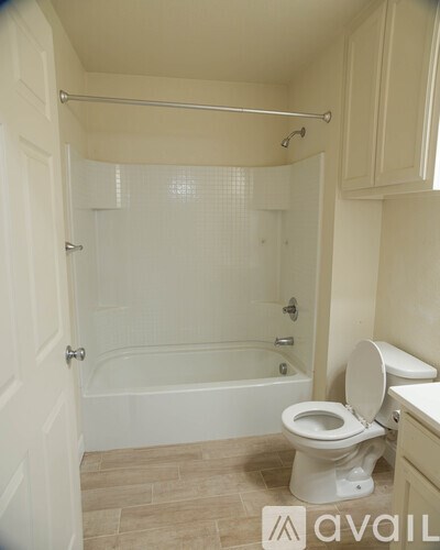 A bathroom with a toilet, tub, and towel rack.