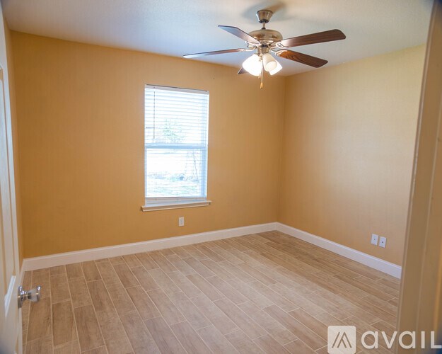 A room with a ceiling fan and a window.