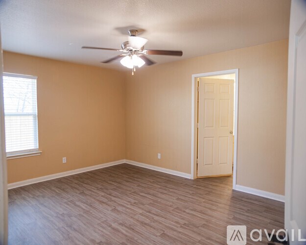 A room with a ceiling fan and a door.