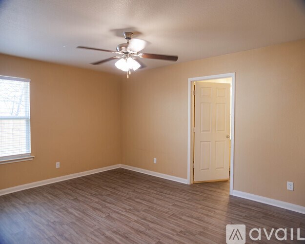 A room with a ceiling fan and a door.