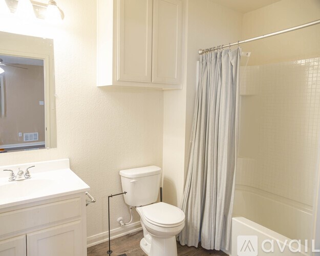 A white bathroom with a toilet, sink, and shower.