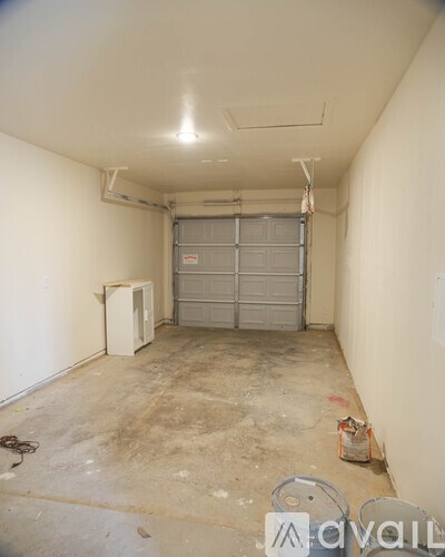 A room with a garage door and a white wall.