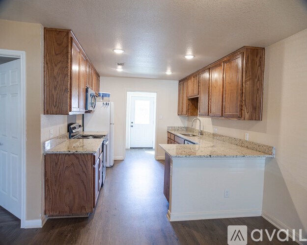A kitchen with wooden cabinets and granite countertops is available.