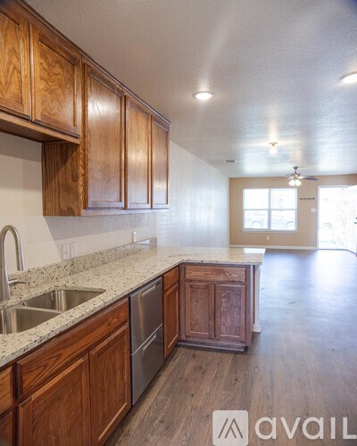 A kitchen with wooden cabinets and a granite countertop.