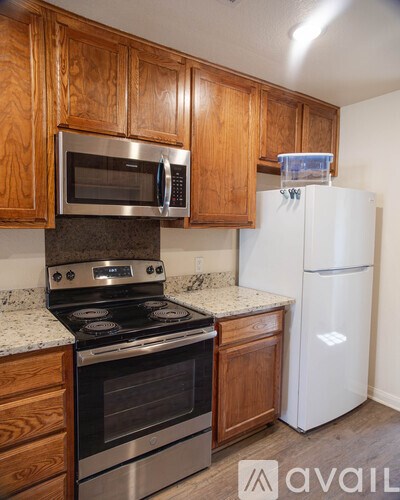 A kitchen with wooden cabinets and a white fridge.