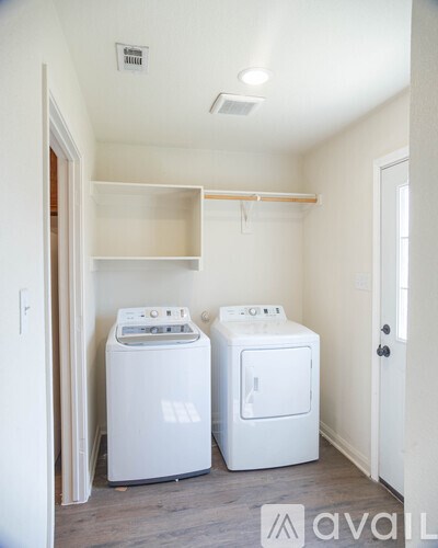 A small laundry room with a washer and dryer.