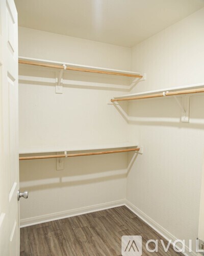 A white closet with three shelves and a door.