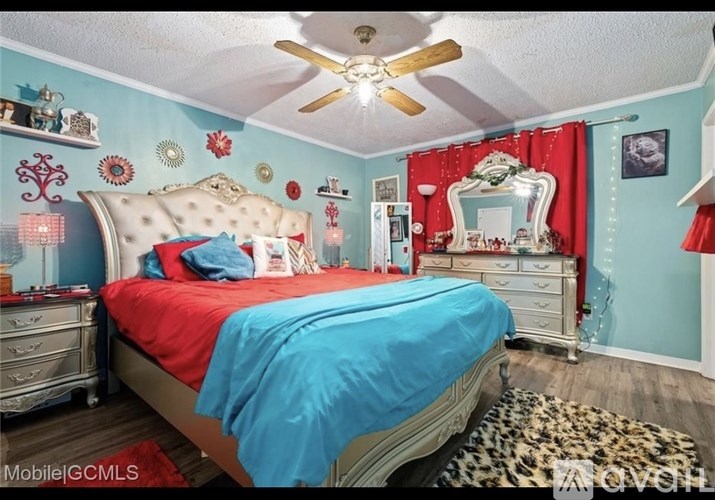 A bedroom with a bed, dresser, and mirror.