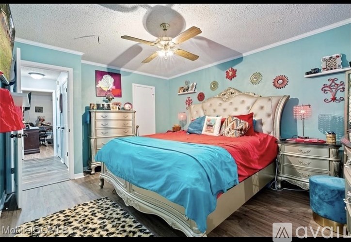 A bedroom with a bed, dresser, and ceiling fan.