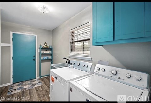 A kitchen with a white stove top oven and blue cabinets.