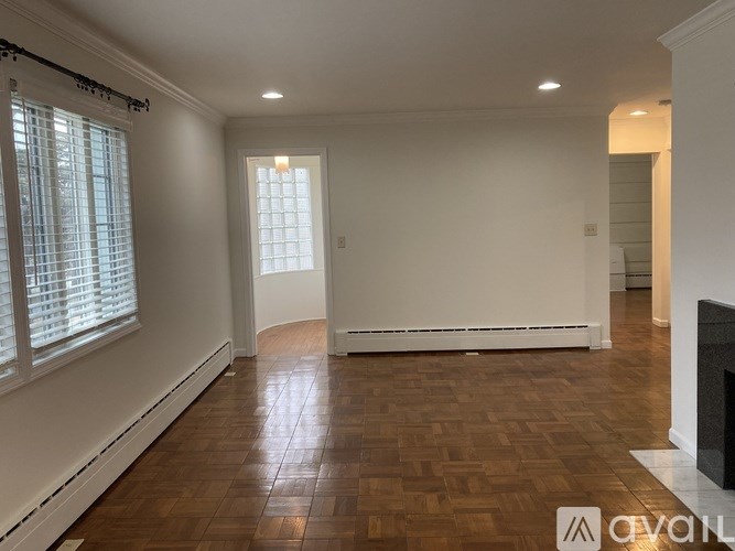 A room with wooden flooring and a fireplace.