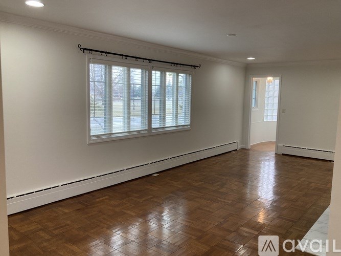 A room with wooden flooring and white walls.