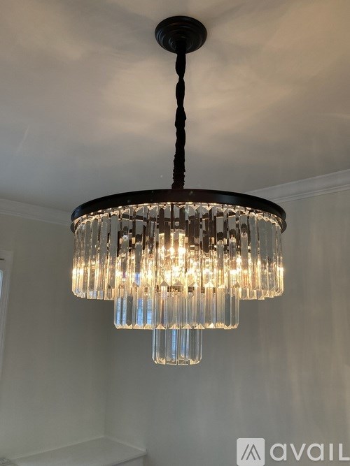 A chandelier with a black metal frame and clear glass shades hangs from the ceiling.