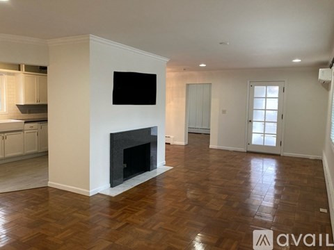 A living room with a fireplace and a television on the wall.