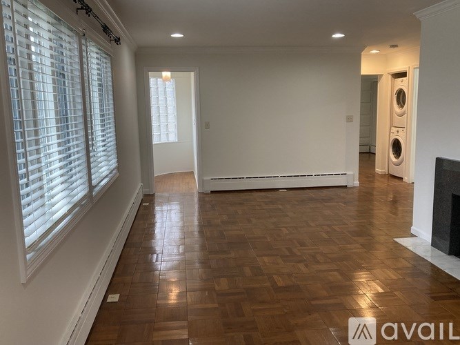 A room with wooden flooring and a fireplace.