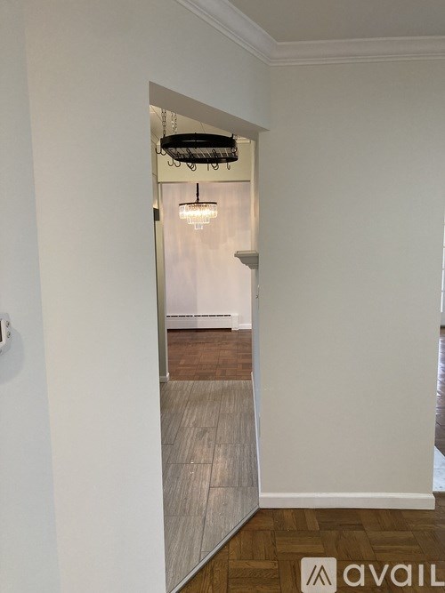 A hallway with a light on and a door at the end.