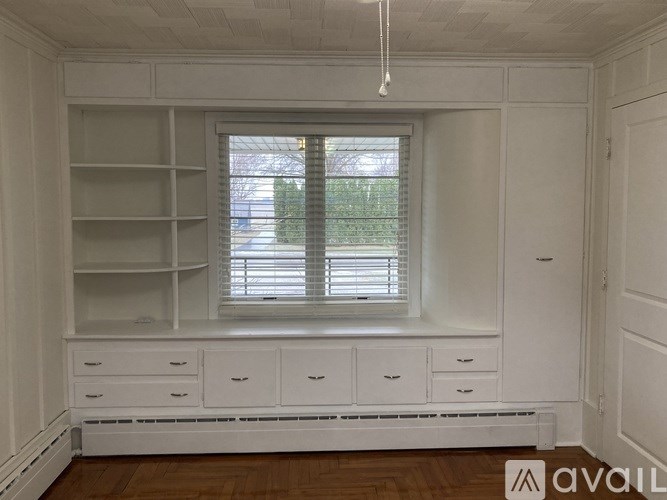 A white room with a window and a radiator beneath it.