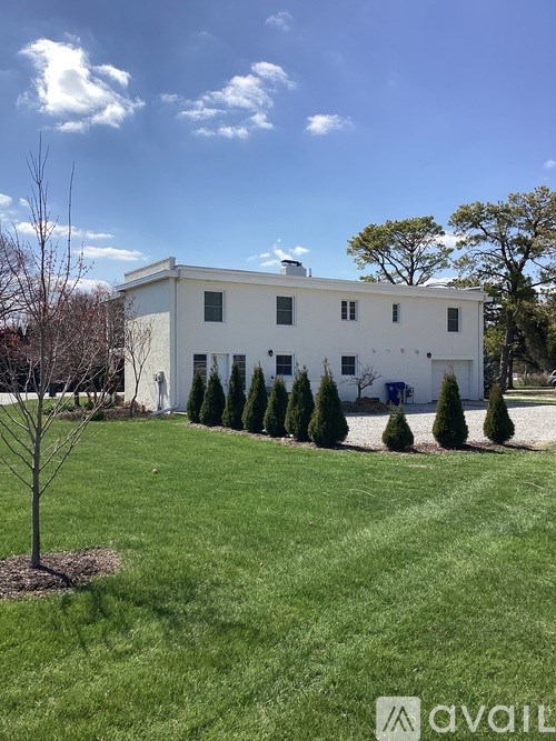 A white building with a tree in front of it.