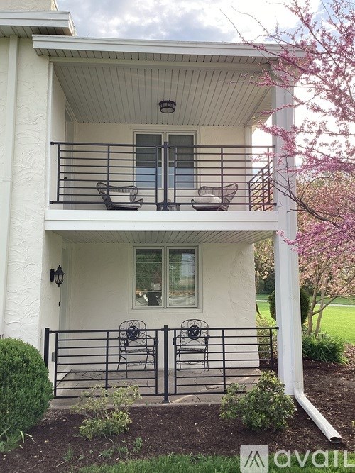A white house with a balcony and a black railing.