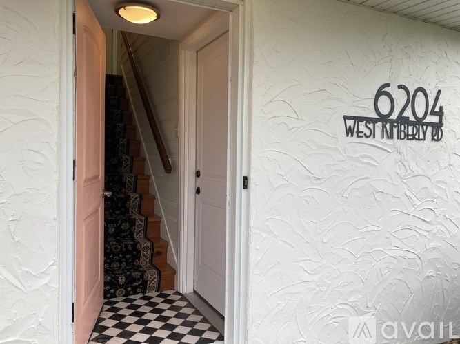 A hallway with a staircase and a wall with the number 6204 on it.