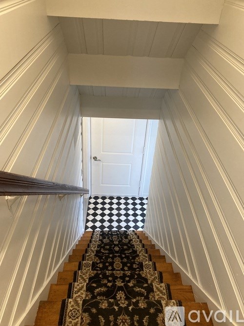 A staircase with a black and white checkered floor.