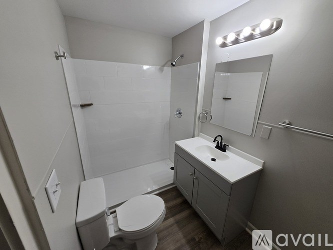 A bathroom with a toilet, sink, and mirror.