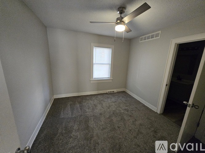 A room with a ceiling fan and a window.