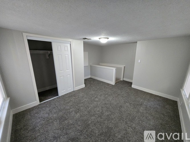 A room with a grey carpet and white walls.